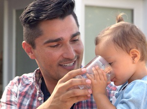Man giving child water