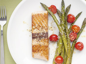 Plate of grilled salmon, asparagus and tomatoes.